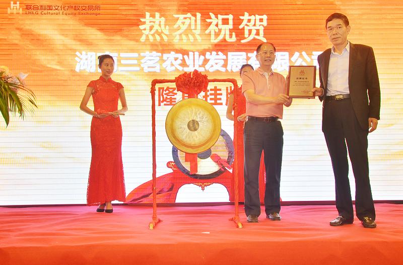 湖南省委宣传部副部长杨金鸢（左一）在挂牌仪式上为湖南三茗农业发展有限公司董事长陈光耀颁发挂牌上市牌匾。.JPG