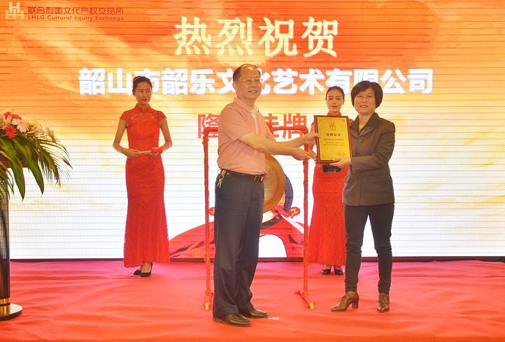 湖南省委宣传部副部长杨金鸢(左一)在挂牌仪式上为韶山市韶乐文化艺术有限公司财务总监谭映芳颁发挂牌上市牌匾。.JPG