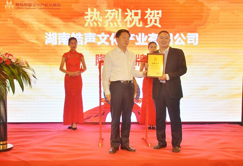 长沙市副市长何寄华（左一）在挂牌仪式上为湖南皓声文化产业有限公司董事长吕贤志颁发挂牌上市牌匾。.JPG