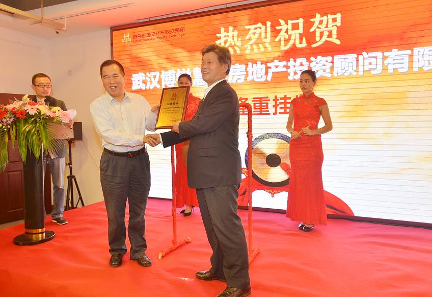 湖南省文化厅副厅长肖凌之（左一）在挂牌仪式上为武汉博锐慧通房地产投资顾问有限公司董事长曾宪上市牌匾。.JPG