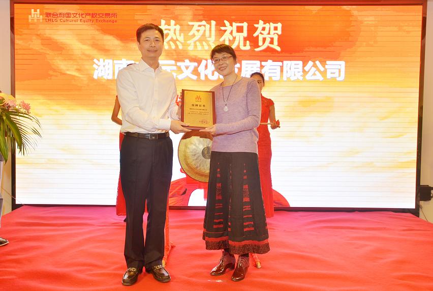 天心区区委副书记王雄文（左一）在挂牌仪式上为湖南中元文化发展有限公司总经理夏莹颁发挂牌上市牌匾。.JPG