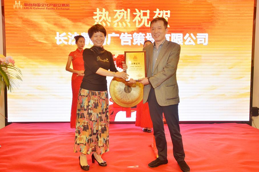 天心区政府副区长刘晓蓉（左一）在挂牌仪式上为长沙凯腾广告策划有限公司总经理罗劲松颁发挂牌上市牌匾。.JPG