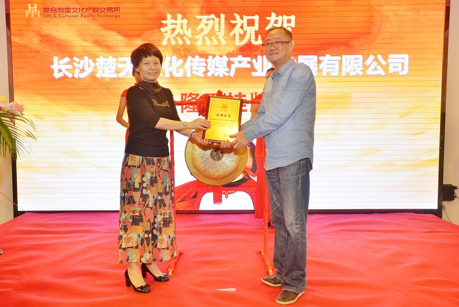 天心区政府副区长刘晓蓉（左一）在挂牌仪式上为长沙楚天文化传媒产业发展有限公司董事长胡卫国颁发挂牌上市牌匾。.JPG