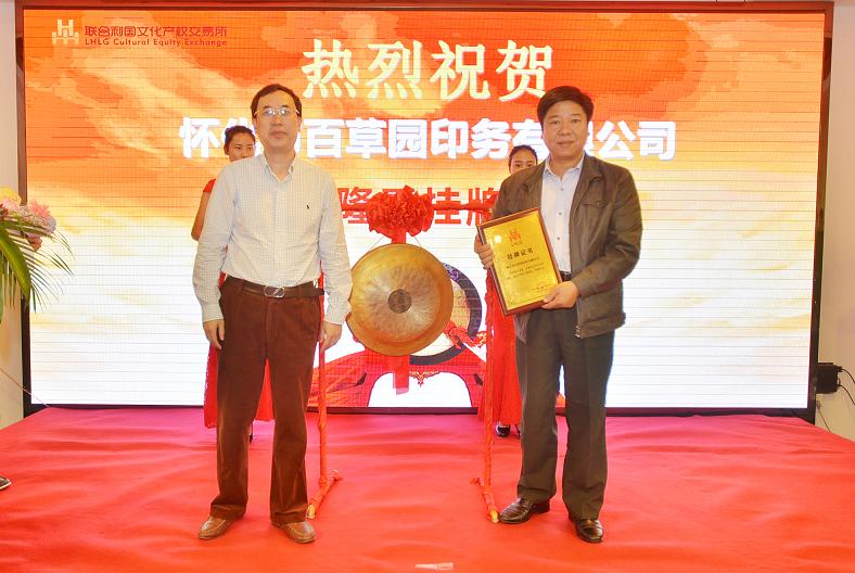 湖南省财政厅文资办主任唐建华（左一）在挂牌仪式上为怀化市百草园印务有限公司董事长谢景宣颁发挂牌上市牌匾。.JPG