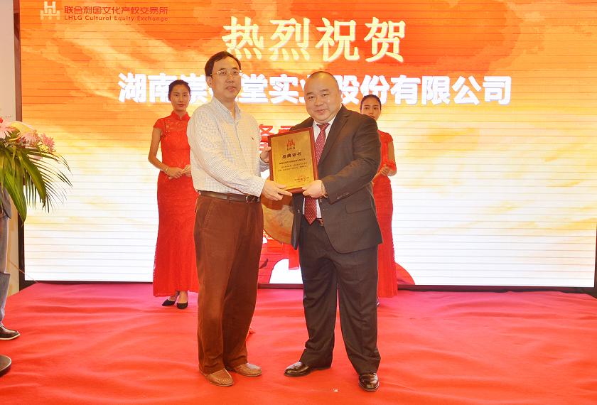 湖南省财政厅文资办主任唐建华（左一）在挂牌仪式上为湖南崇德堂实业股份有限公司董事长苏晓浪颁发挂牌上市牌匾。.JPG