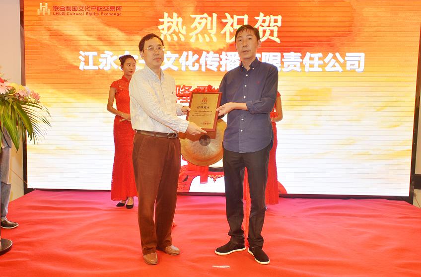 湖南省财政厅文资办主任唐建华（左一）在挂牌仪式上为江永女书文化传播有限责任公司董事长何佳星颁发挂牌上市牌匾。.JPG