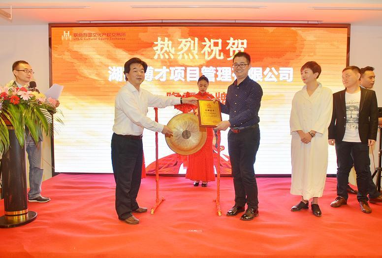 湖南日报报业集团副总经理、联合利国文交所副董事长杨山青（左一）在挂牌仪式上为湖南博才项目管理有限公司总经理卢启辉颁发挂牌上市牌匾。.JPG