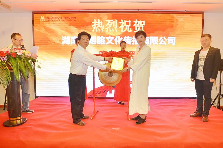 湖南日报报业集团副总经理、联合利国文交所副董事长杨山青（左一）在挂牌仪式上为湖南省朗路文化传播有限公司总经理曾昕颁发挂牌上市牌匾。.JPG