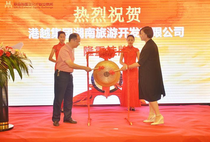 湖南省委宣传部副部长杨金鸢(左一)在挂牌仪式上与港越集团湖南旅游开发有限公司周香香女士共同敲锣。.JPG