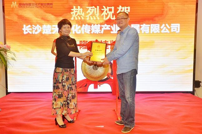 天心区政府副区长刘晓蓉（左一）在挂牌仪式上为长沙楚天文化传媒产业发展有限公司董事长胡卫国颁发挂牌上市牌匾。.JPG