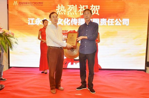 湖南省财政厅文资办主任唐建华（左一）在挂牌仪式上为江永女书文化传播有限责任公司董事长何佳星颁发挂牌上市牌匾。.JPG