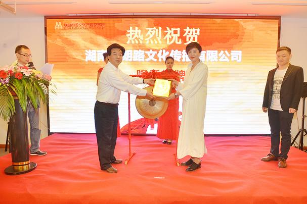 湖南日报报业集团副总经理、联合利国文交所副董事长杨山青（左一）在挂牌仪式上为湖南省朗路文化传播有限公司总经理曾昕颁发挂牌上市牌匾。.JPG