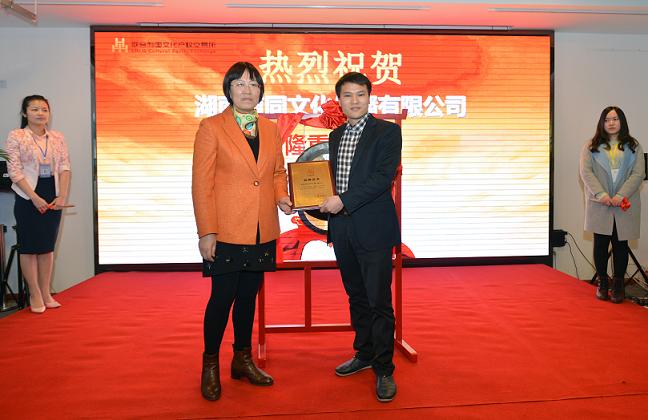 湖南省委宣传部文资办主任向艳（左一）为湖南道同文化传播有限公司董事长李淼兴（右一）颁发牌匾.JPG